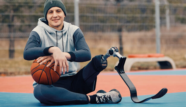 Junger Basketballspieler mit einer modernen Beinprothese