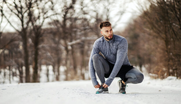 Sport im Winter, ein Mann joggt im Wald