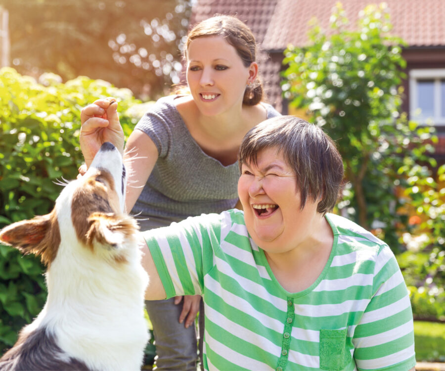 Geistig behinderte Frau spielt mit Hund. Symbolbild Advertorial Albert Schweitzer Wohnen und Leben©M.Dörr & M.Frommherz/stock.adobe.com