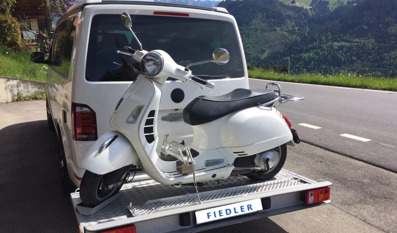 Der Heckträger von Fiedler Reismobiltechnik kann problemlos einen Motorroller transportieren.