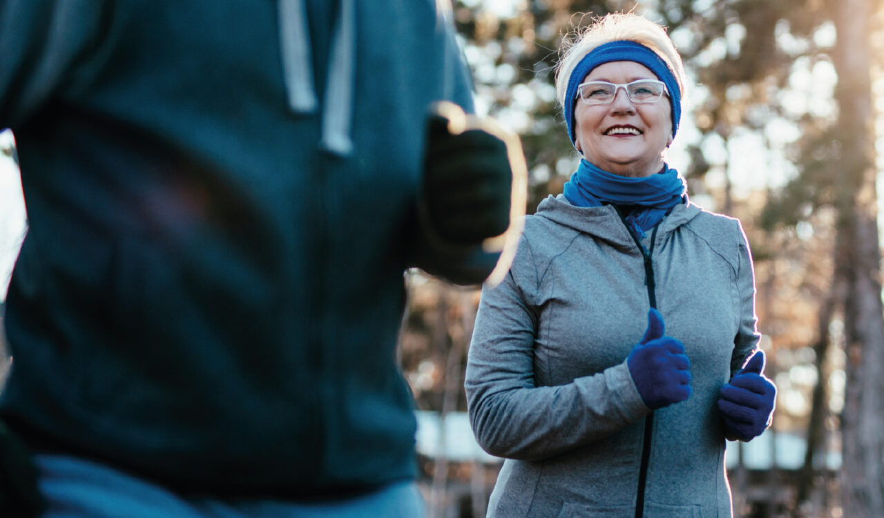 Eine Rentnerin und ein Begleiter beim Jogging im Winter